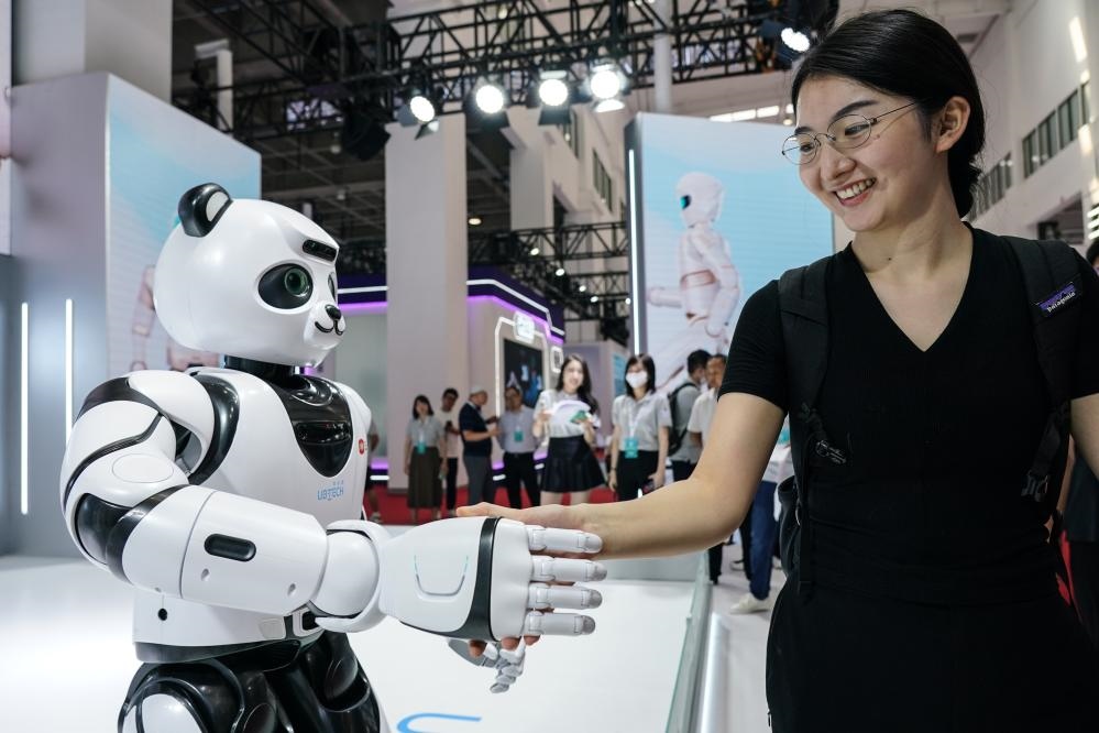 2023年8月16日，一名女士在北京舉辦的2023世界機(jī)器人大會(huì)現(xiàn)場(chǎng)與智能機(jī)器人握手。新華社記者彭子洋攝