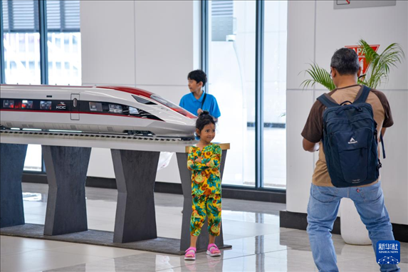 1月24日，在印度尼西亞雅加達(dá)哈利姆站候車大廳，一名小朋友和雅萬高鐵高速動(dòng)車組模型合影。新華社記者 徐欽 攝