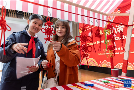1月28日，復(fù)旦大學(xué)第二附屬學(xué)校學(xué)生（左）為美國馬斯卡廷中學(xué)學(xué)生（右）介紹中國結(jié)。 新華社記者 王翔 攝