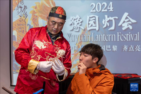 1月28日，在上海豫園舉行的民俗活動上，美國馬斯卡廷中學(xué)學(xué)生在非遺傳承人的指導(dǎo)下吹糖偶。 新華社記者 王翔 攝