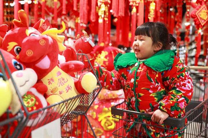 1月23日，在貴州省黔東南苗族侗族自治州岑鞏縣一家超市，小朋友在家人的帶領下選購龍年毛絨玩具。新華社發(fā)（唐鵬攝）