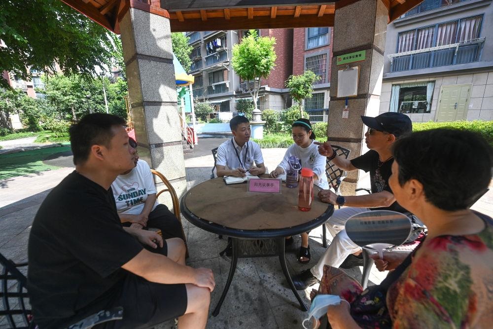 △2023年7月21日，在位于浙江杭州臨安區(qū)錦南街道水岸陽光小區(qū)的陽光議事廳，街道干部在聽取居民們反映的問題及意見。
