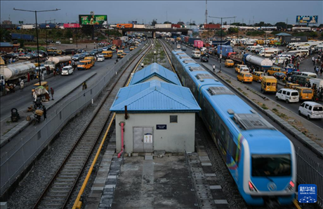 3月4日，在尼日利亞拉各斯，一列輕軌藍線列車行駛至公路交通擁堵路段附近。新華社記者 韓旭 攝
