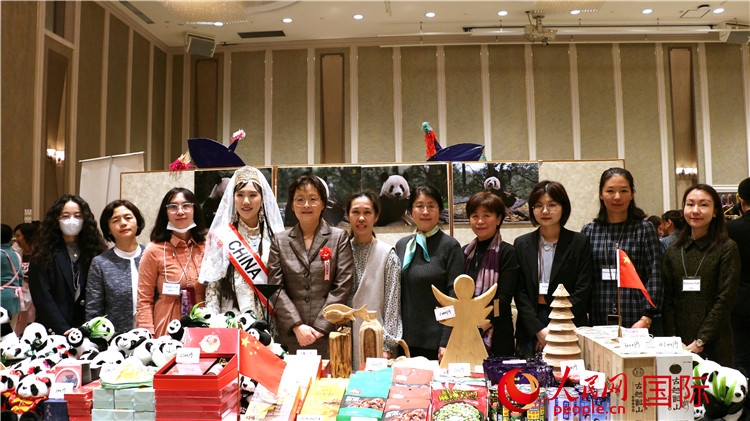 中國駐日本大使吳江浩夫人丁玥（左五）與使館人員在展位前合影留念。人民網(wǎng) 許可攝