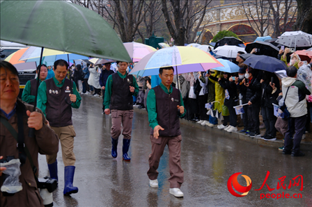 飼養(yǎng)員姜哲遠(yuǎn)和宋永寬為“福寶”開(kāi)路送行。人民網(wǎng) 李帆攝