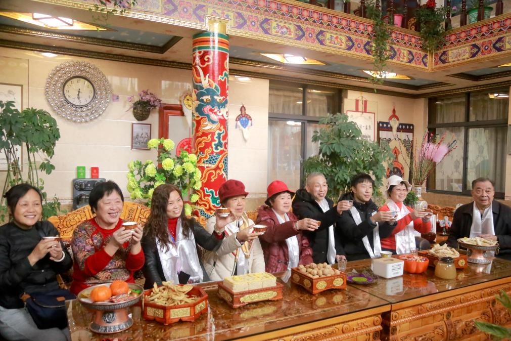 游客們?nèi)胱∶袼藓螅e杯共飲酥油茶。新華社記者 邱星翔 攝