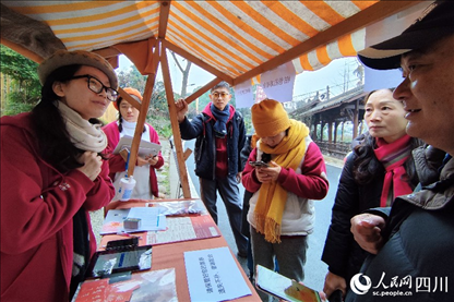 1月6日，“2024成都蒲江柑甜采摘節(jié)”上，記者見到了小萌（左一）和許多年輕人忙著做訪客接待、現(xiàn)場布置、票務(wù)核對(duì)、采摘服務(wù)等工作。人民網(wǎng)記者朱虹攝