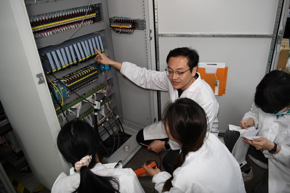 2024年4月6日，在位于安徽合肥的中國科學(xué)技術(shù)大學(xué)，安徽省先進功能高分子薄膜工程實驗室團隊成員在檢修自主研制的高分子薄膜原位雙向拉伸實驗設(shè)備的電氣控制系統(tǒng)。