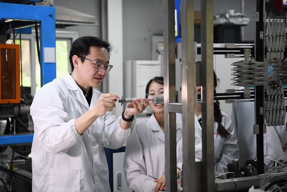 2024年4月6日，在位于安徽合肥的中國科學(xué)技術(shù)大學(xué)，安徽省先進功能高分子薄膜工程實驗室團隊成員朱健和（左）在和同事討論實驗設(shè)備的設(shè)計方案。