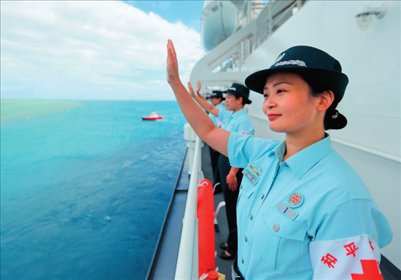 中國海軍“和平方舟”號(hào)醫(yī)院船結(jié)束訪問湯加時(shí)，任務(wù)官兵中的文職人員向歡送人群揮手告別（2023年8月4日攝）。徐巍攝/本刊