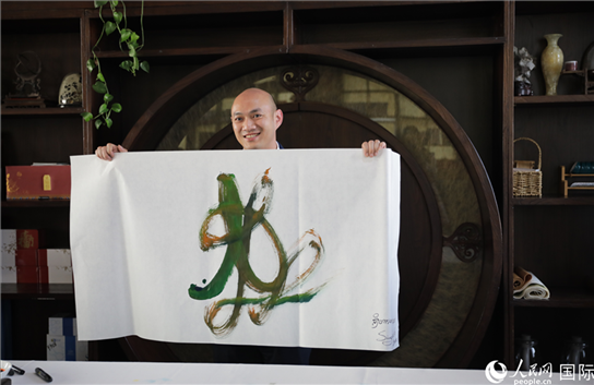 老撾駐華大使館三秘明君參加《五百筆·瀾湄合作》集體藝術(shù)創(chuàng)作。人民網(wǎng)王婧攝。