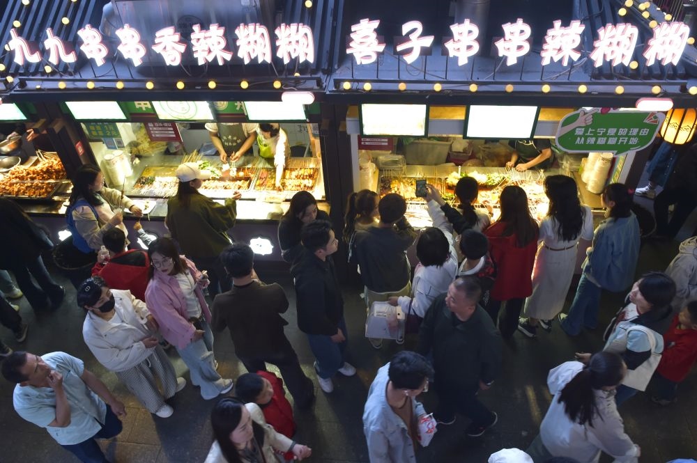 2024年5月4日，游客在寧夏銀川懷遠(yuǎn)夜市品嘗當(dāng)?shù)鼐W(wǎng)紅美食辣糊糊。新華社記者 毛竹 攝