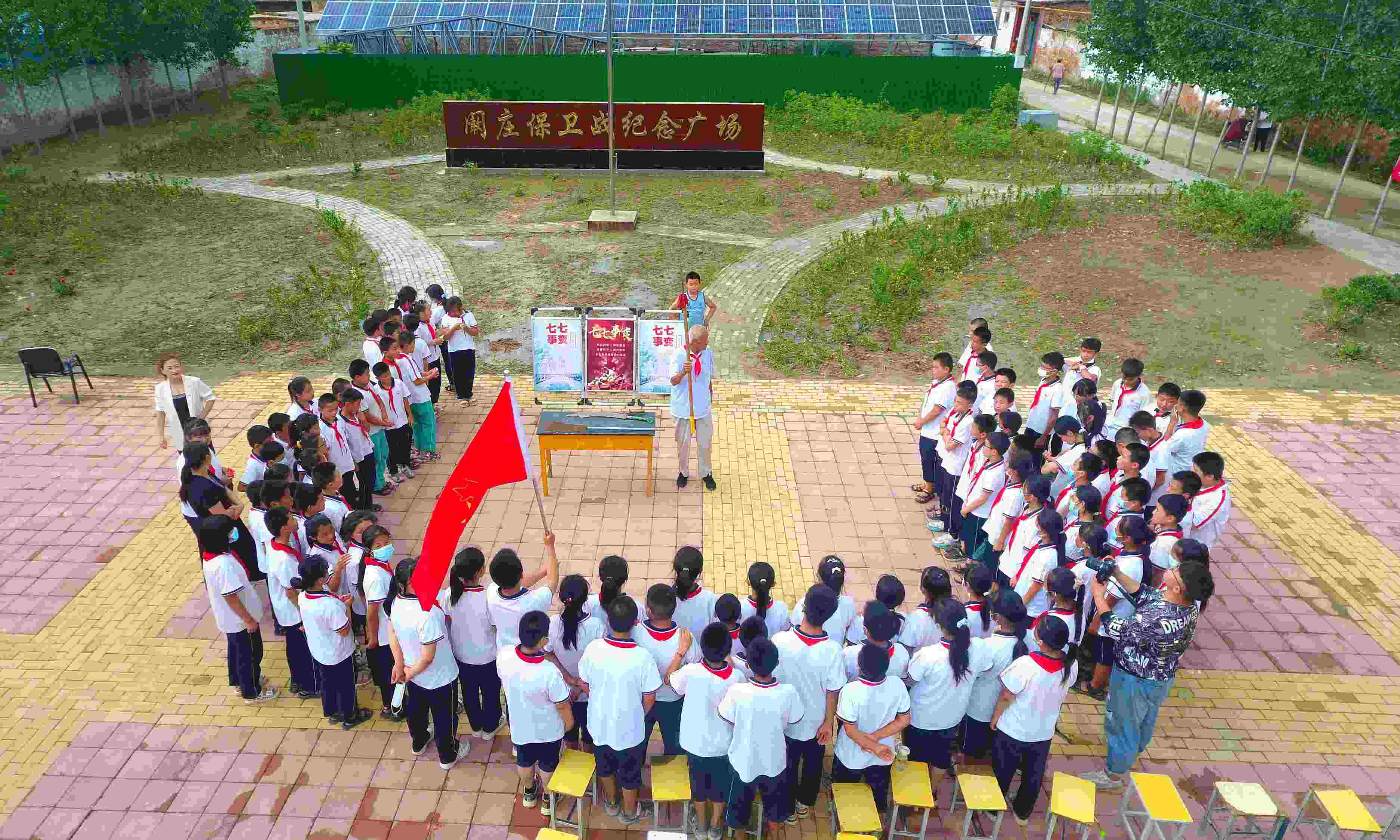 2022年7月6日，山東省聊城市，在茌平區(qū)菜屯鎮(zhèn)闞莊村的闞莊保衛(wèi)戰(zhàn)紀(jì)念廣場，闞莊保衛(wèi)戰(zhàn)親歷者王光木老人為小學(xué)生們講述抗戰(zhàn)故事，展示大刀、長矛。