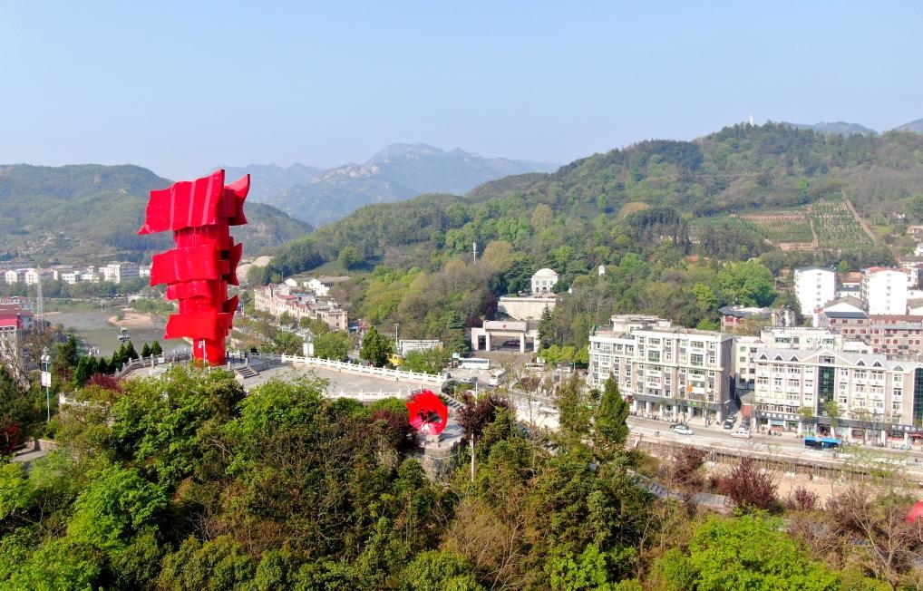 這是2021年4月9日拍攝的鄂豫皖蘇區(qū)首府革命博物館附近的英雄山上的“紅旗飄飄”主題雕塑（無人機(jī)照片）。新華社發(fā)