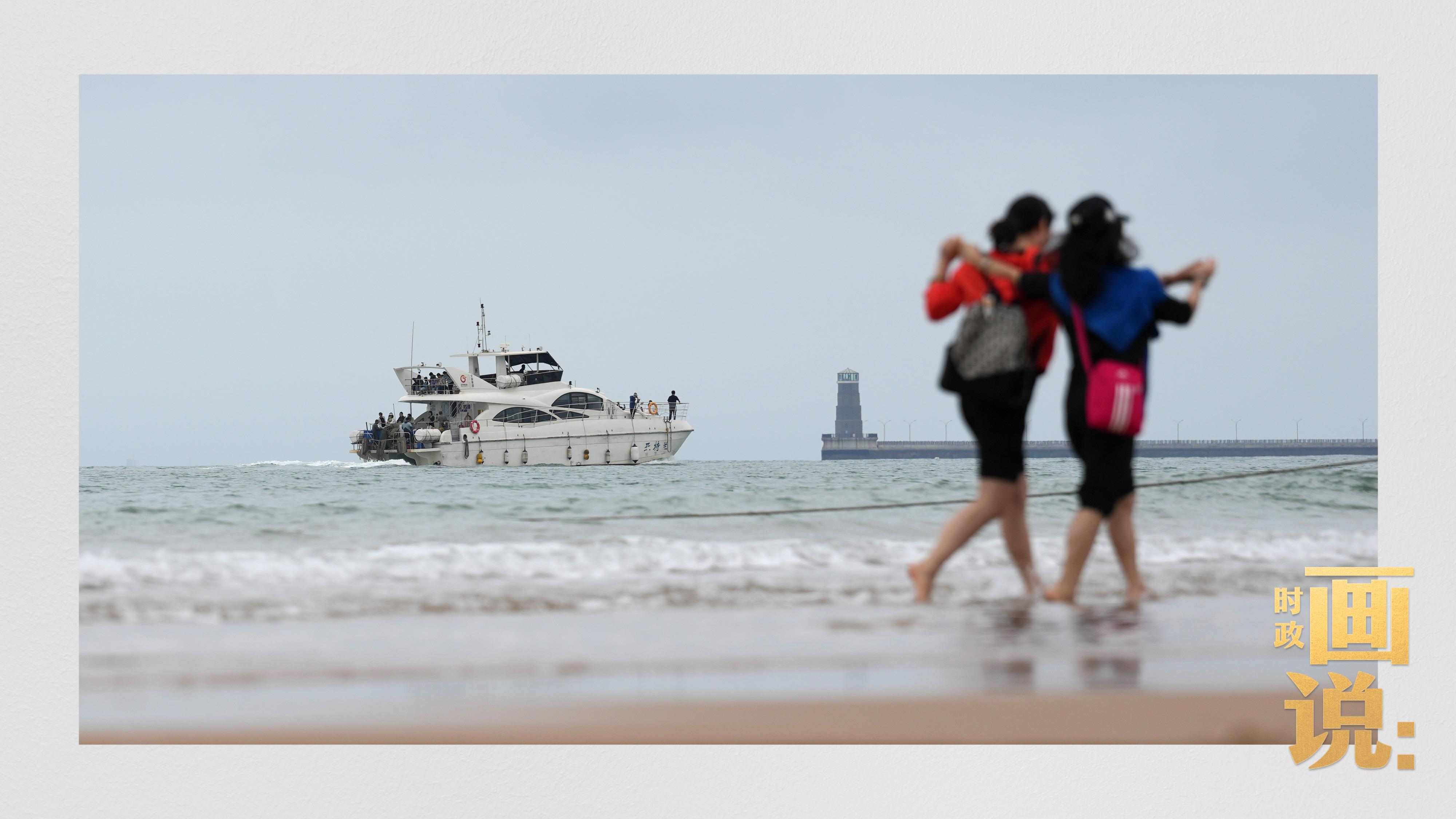 △日照陽光海岸綠道上的萬平口景區(qū)，一對游客在海浪中翩然起舞。