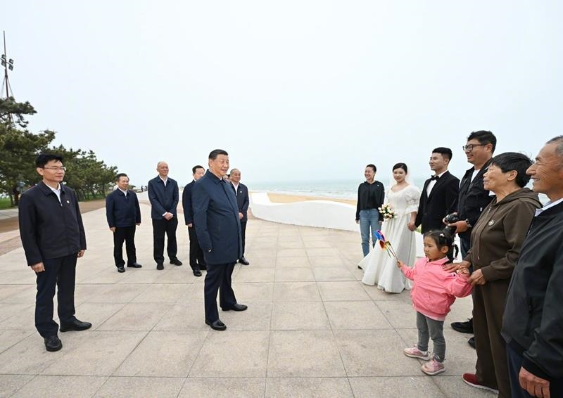 5月22日，在山東日照考察調(diào)研的習(xí)近平總書記來到陽光海岸綠道，同市民游客親切交流。