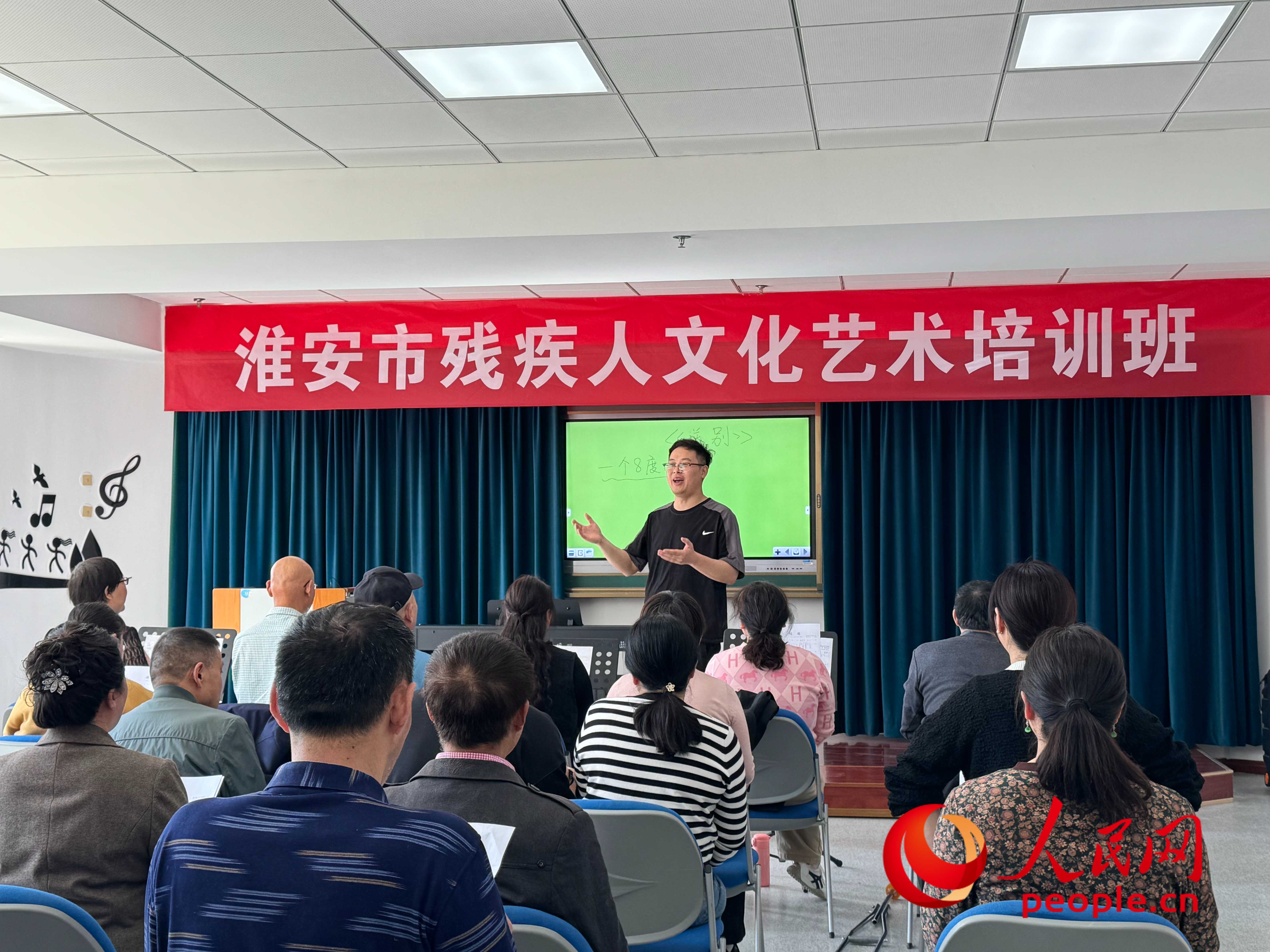 在淮安市殘疾人文化藝術(shù)培訓(xùn)班上，聲樂老師在教殘疾人唱《送別》這首歌曲。人民網(wǎng) 周靜圓攝