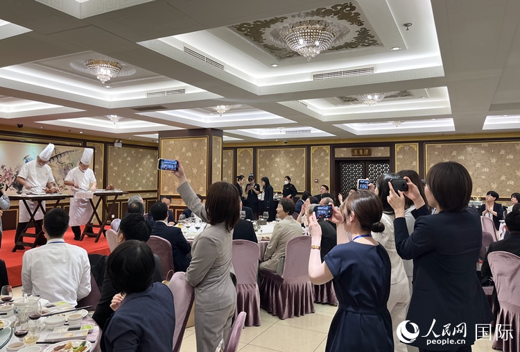 國家級非物質(zhì)文化遺產(chǎn)、全聚德片鴨工藝吸引代表團(tuán)成員拍照留念。