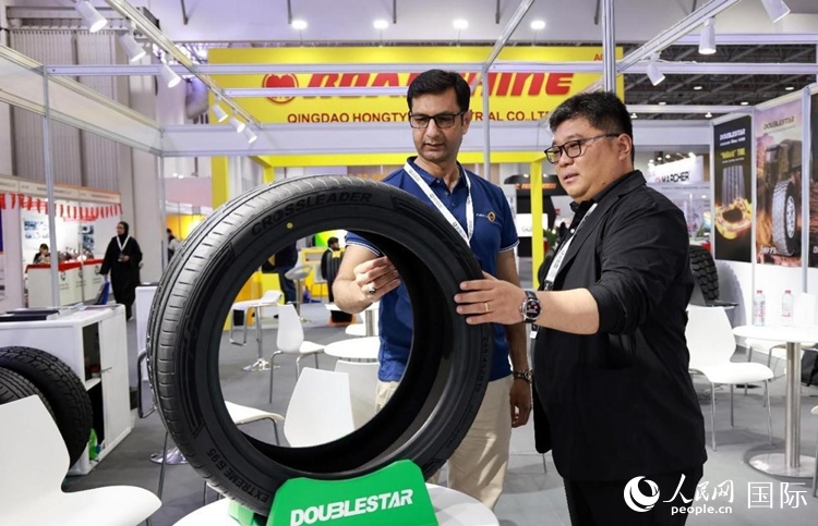 工作人員向客戶展示雙星電動汽車輪胎。和傳統(tǒng)汽車輪胎相比，電動汽車輪胎具有更高承載能力、更加靜音舒適、更好極速抓地、更低滾動阻力等特點。人民網(wǎng)記者 管克江攝