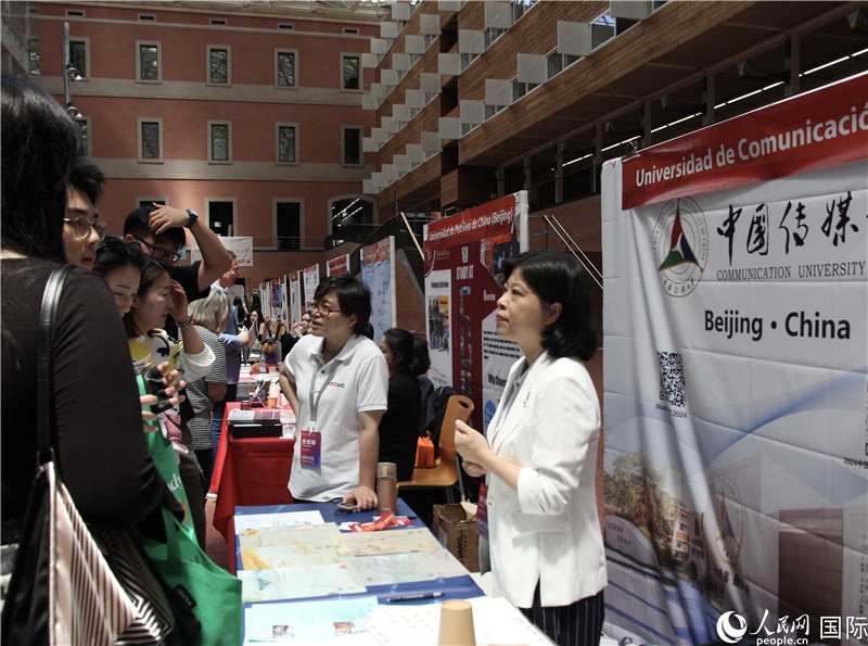 旅西華人華僑在展臺前咨詢。人民網(wǎng)記者 許海林攝
