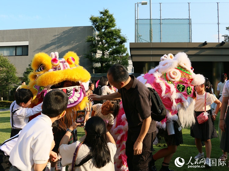 孩子們好奇地圍觀舞獅。人民網(wǎng) 許可攝