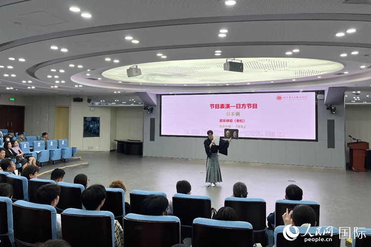 日本大學(xué)生介紹能樂知識。人民網(wǎng)記者 陳思攝