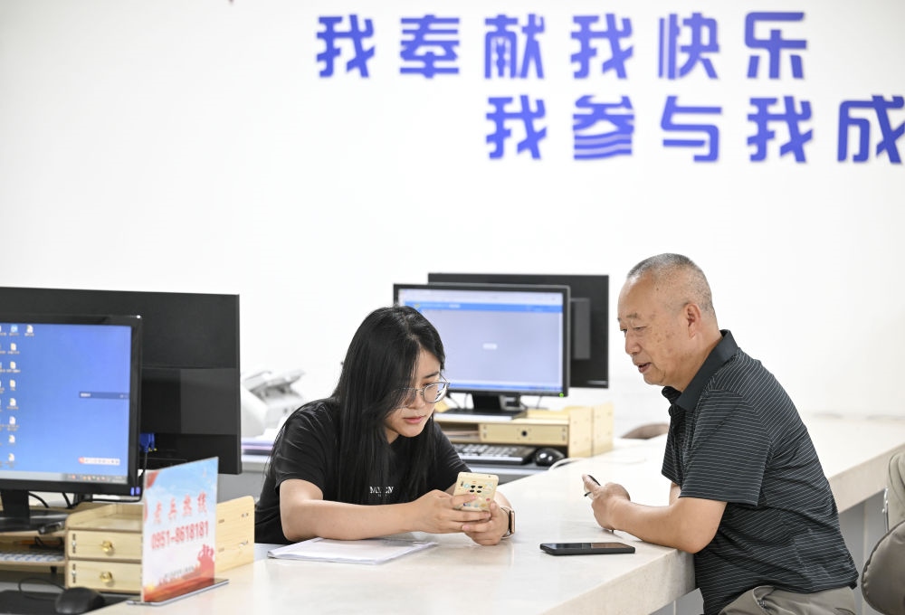 6月20日，在長城花園社區(qū)黨群服務(wù)中心，工作人員幫助居民辦理業(yè)務(wù)。