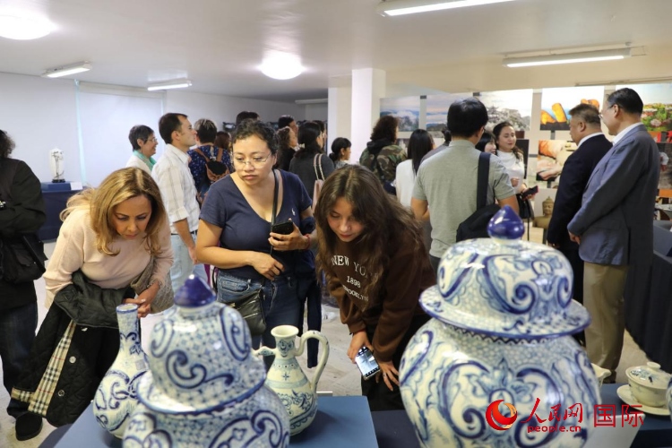 在展覽現(xiàn)場(chǎng)，觀眾們駐足欣賞德化瓷和墨西哥彩瓷。人民網(wǎng) 埃內(nèi)斯托·多明戈斯攝