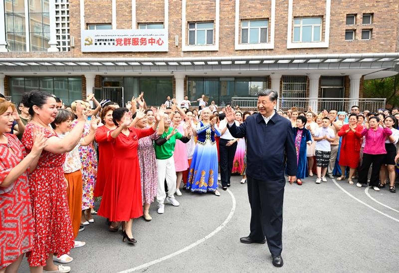 2022年7月13日，習(xí)近平總書(shū)記在新疆烏魯木齊市天山區(qū)固原巷社區(qū)考察時(shí)，向各族群眾揮手致意。