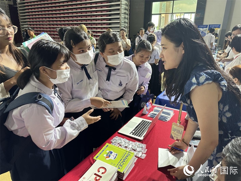 來自泰國的學(xué)生、家長在教育展臺前咨詢。人民網(wǎng)記者 簡承淵攝
