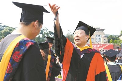 2017年6月22日，李德仁（右一）參加武漢大學(xué)畢業(yè)典禮并為畢業(yè)生撥穗。