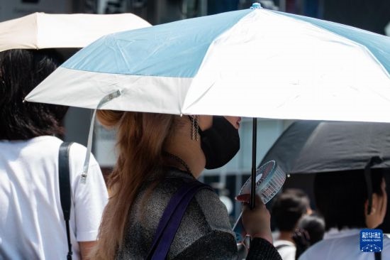 7月4日，人們?cè)谌毡緰|京原宿的街道上等待紅綠燈。新華社記者 張笑宇 攝