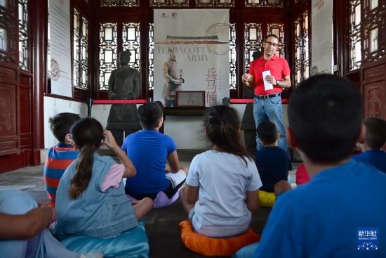 7月4日，在馬耳他桑塔露琪亞市的中國古典園林“靜園”，人們聆聽關(guān)于兵馬俑的講解。新華社發(fā)（喬納森·博格 攝）