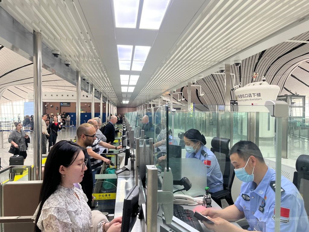 7月5日，北京大興國際機(jī)場邊檢站民警正在辦理邊檢查驗(yàn)手續(xù)。（北京大興國際機(jī)場邊檢站供圖）