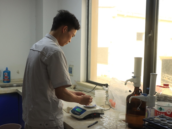 武漢直屬庫租倉點質(zhì)檢員正在對小麥進(jìn)行質(zhì)量檢測。受訪者供圖