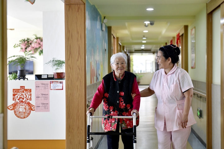 2024年5月25日，在山東省日照市東港區(qū)石臼街道日照幸福護(hù)理院，工作人員在陪護(hù)老人。新華社記者 郭緒雷 攝