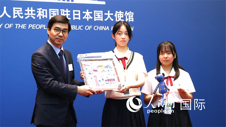 日本小大使向中國駐日本大使館臨時代辦施泳贈送當?shù)靥厣Y品。人民網(wǎng) 許可攝