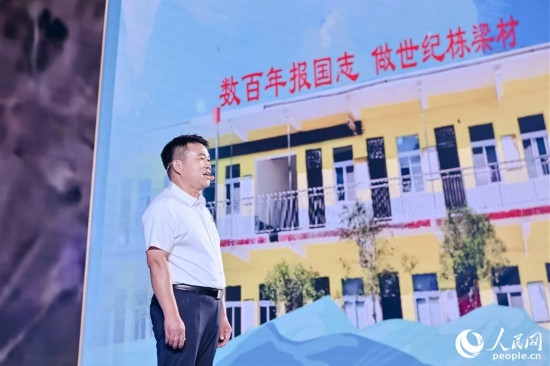 張玉滾分享用一根扁擔(dān)送孩子們走出大山的故事。人民網(wǎng)攝