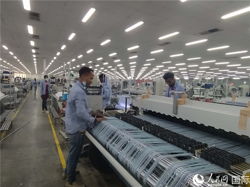 無錫金茂埃塞面料廠車間內(nèi)，當?shù)毓と苏谝唤z不茍地作業(yè)。人民網(wǎng)記者 黃培昭攝