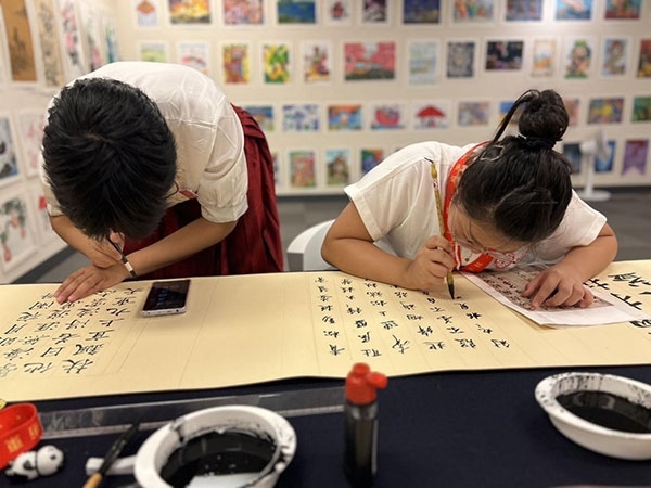 參加本次展覽的青少年在現(xiàn)場進(jìn)行書法創(chuàng)作。主辦方供圖