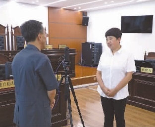 圖為全國人大代表玉明姬（右）詳細了解環(huán)境資源審判工作情況。劉思妤 攝