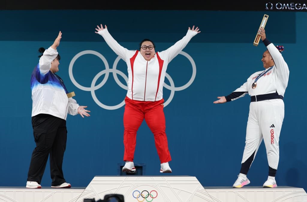 中國(guó)選手李雯雯（中）在巴黎奧運(yùn)會(huì)舉重女子81公斤以上級(jí)頒獎(jiǎng)儀式中登上領(lǐng)獎(jiǎng)臺(tái)（2024年8月11日攝）。新華社記者 楊磊 攝