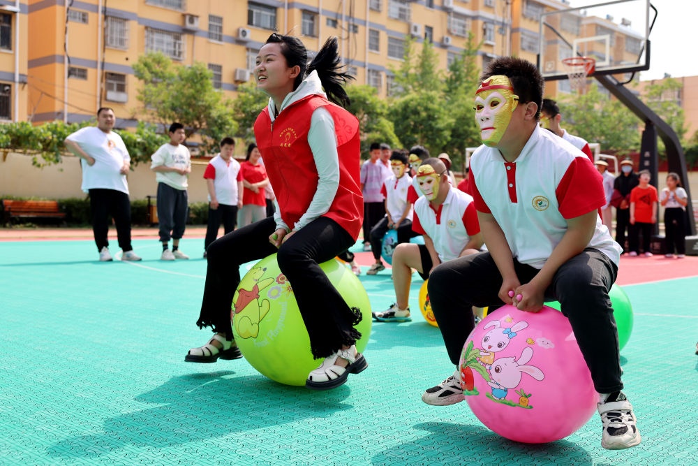 2024年5月17日，在山東省棗莊市市中區(qū)特殊教育中心，青年志愿者與智力障礙學生一起做游戲。新華社發(fā)（孫中喆攝）