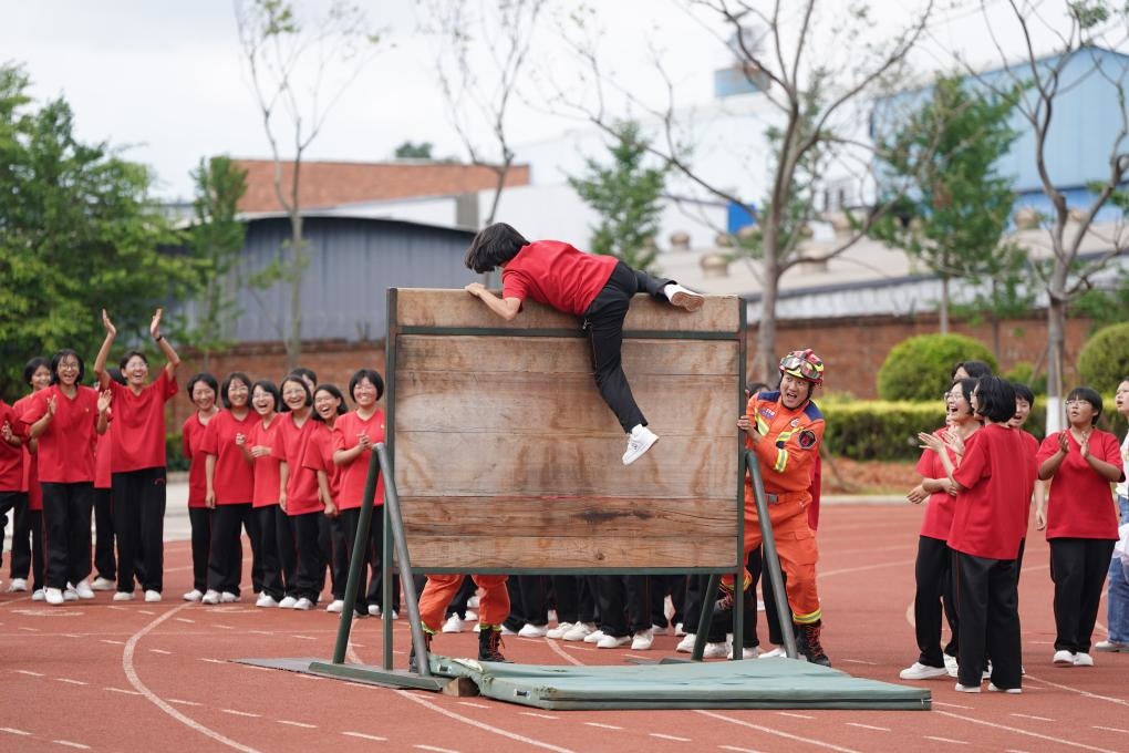 云南麗江華坪女子高級中學(xué)學(xué)生在體驗翻越障礙板。新華社記者陳欣波 攝