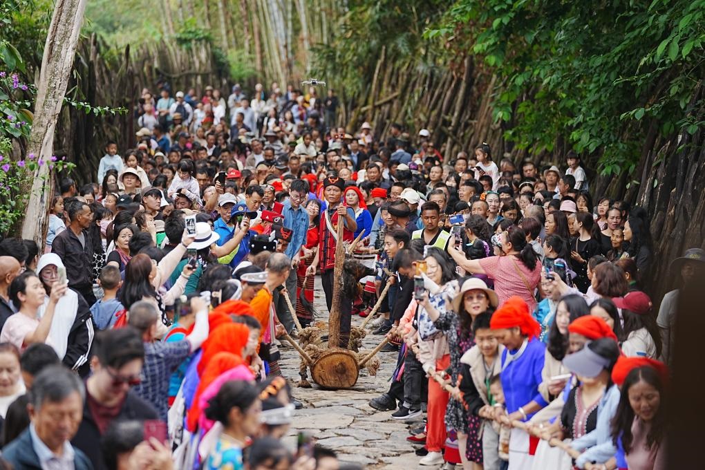 5月3日，各地游客在滄源縣翁丁村和村民一起參加佤族傳統(tǒng)民俗拉木鼓活動(dòng)。（滄源縣融媒體中心供圖）