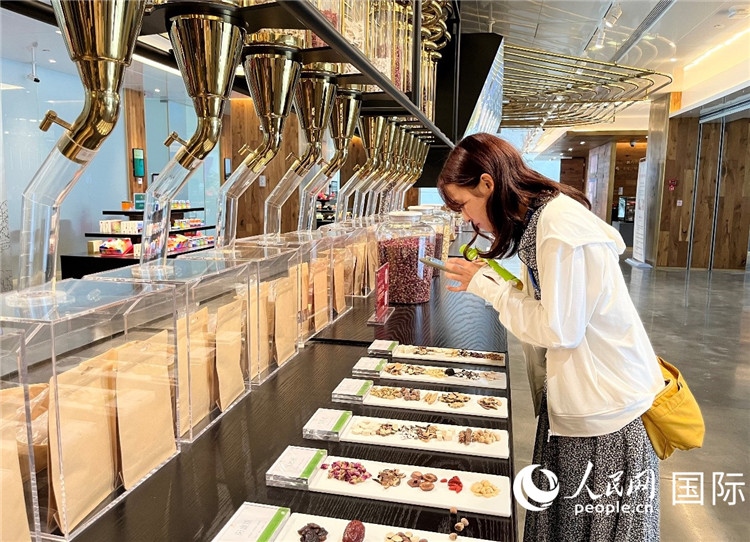 4. 代表團(tuán)團(tuán)員對(duì)新中式茶飲的食材充滿興趣。（人民網(wǎng)記者陳思 攝）