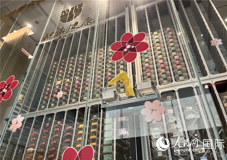 6. 機(jī)械臂正在取貨。（人民網(wǎng)記者陳思 攝）
