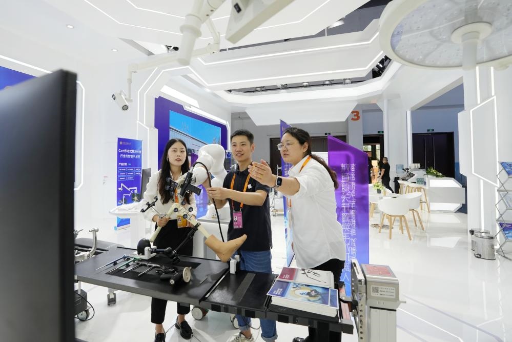 9月11日，一位媒體記者（中）在2024年服貿(mào)會(huì)國家會(huì)議中心會(huì)場體驗(yàn)北京納通科技集團(tuán)有限公司的膝關(guān)節(jié)置換手術(shù)機(jī)器人。新華社記者鞠煥宗 攝
