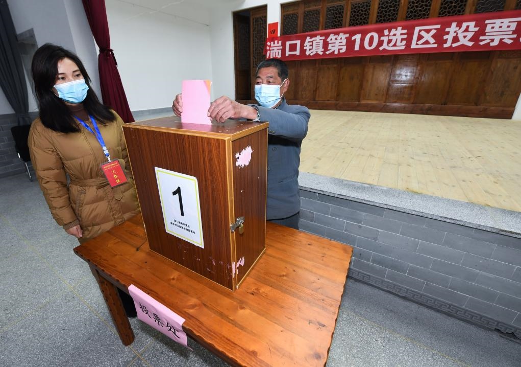 2021年12月14日，在浙江省杭州市臨安區(qū)湍口鎮(zhèn)迎豐村的基層投票點，村民在參加投票，村級監(jiān)察聯(lián)絡(luò)員監(jiān)票。新華社記者 徐昱 攝
