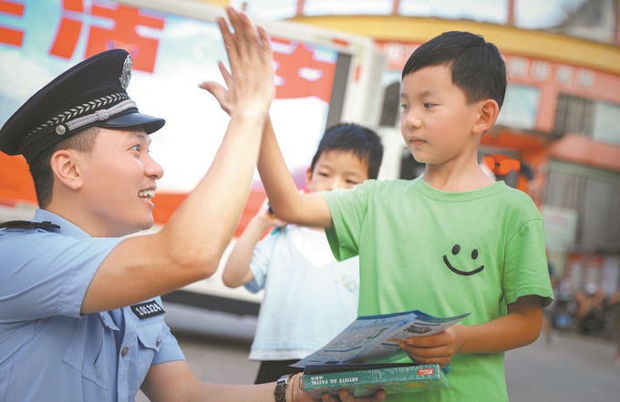 ▲7月10日，江西省吉安市公安局吉州分局組織民警深入轄區(qū)開展安全宣傳，民警向小朋友講解防溺水知識。朱文杰攝